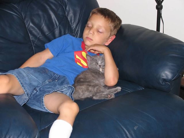 Young Lukas asleep with a small kitten